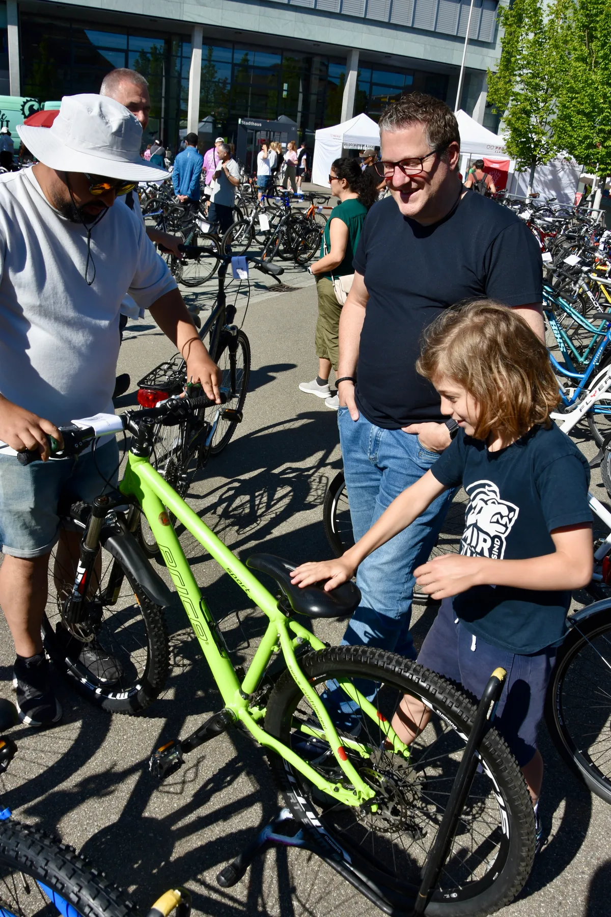 Drei Männer rund um ein Velo. 